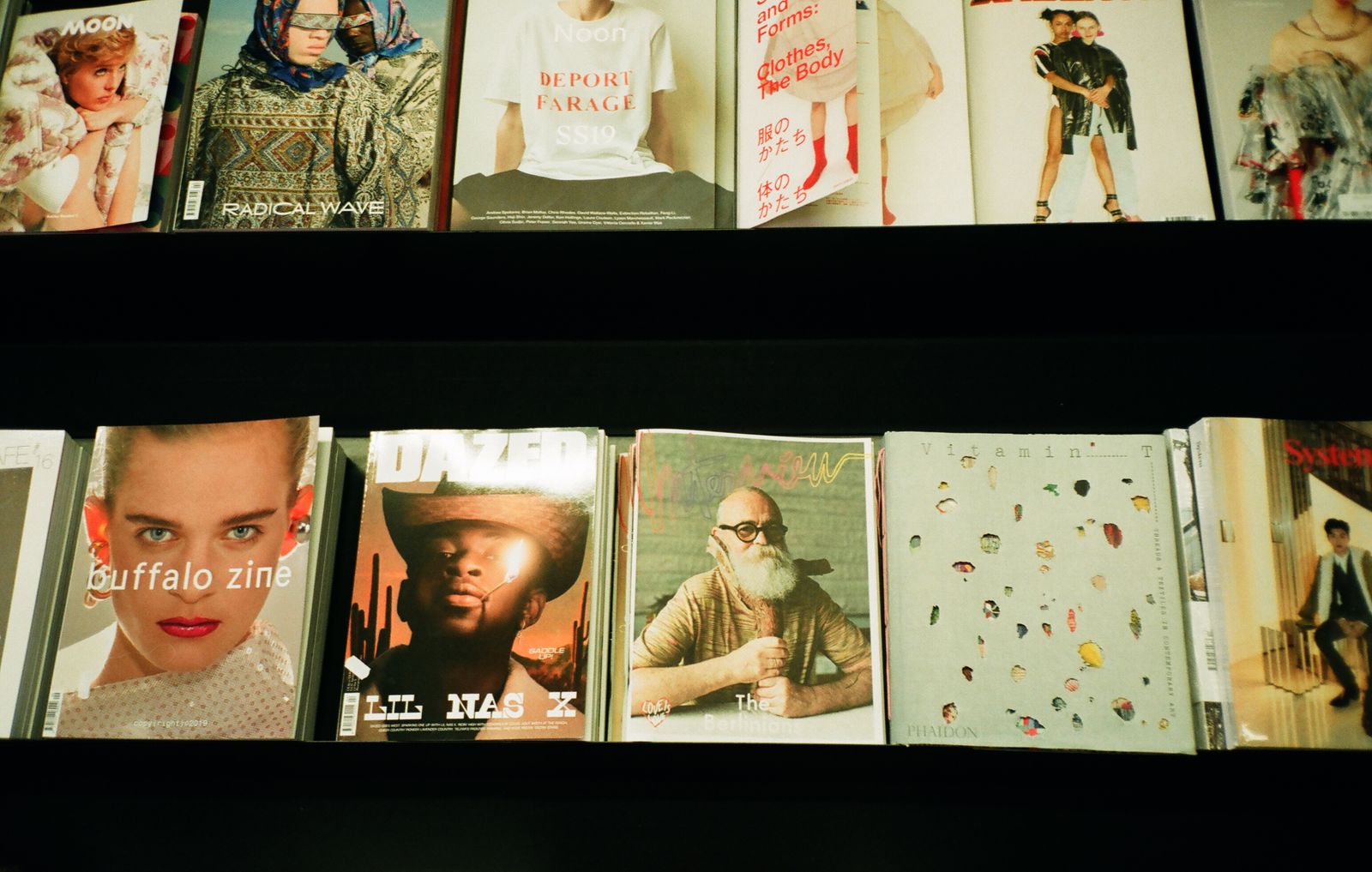 Assortiment coloré de magazines de mode exposés sur une étagère dans une librairie.